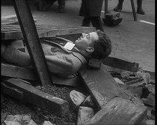 British People Acting Out Bomb attacks and Crashed German Planes, Lying Under Rubble, 1940. Creator: British Pathe Ltd.