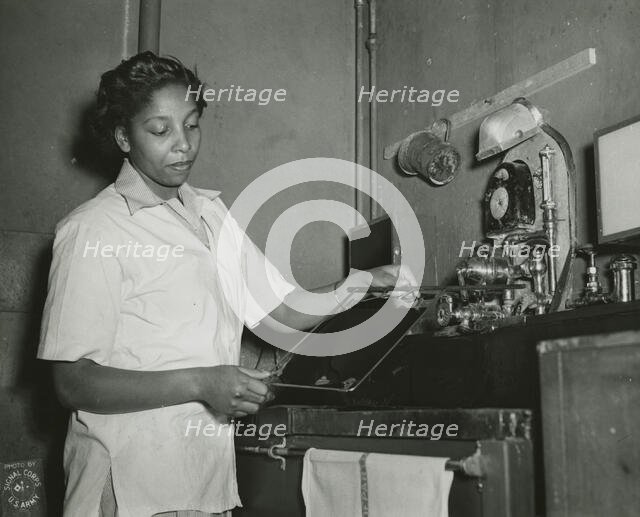 African American Private Hannah Wills developing an x-ray film in the x-ray laboratory..., 1943. Creator: Unknown.
