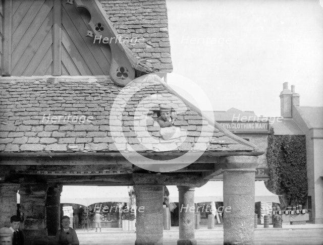 Boy poking his head through the roof of the 17th-century Buttercross, Witney, Oxon, c1860-c1922. Artist: Henry Taunt