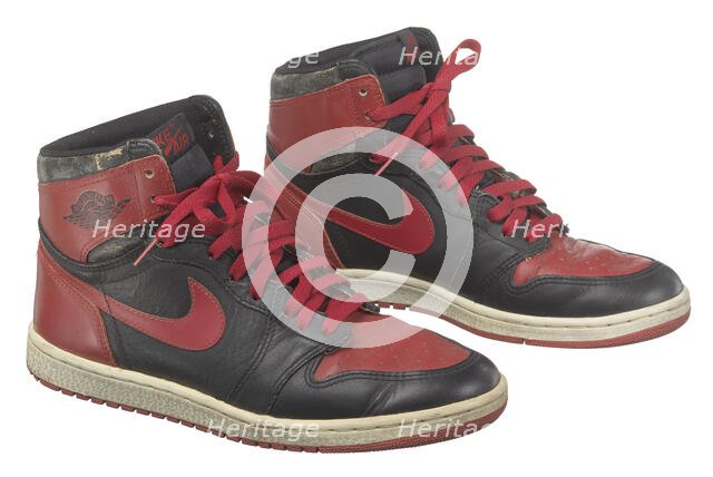 Pair of red and black Air Jordan I high top sneakers made by Nike, 1985. Creator: Nike.