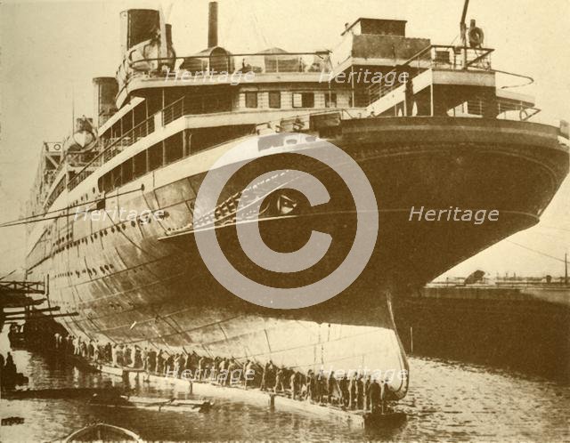 'Cleaning the Hull of the "Majestic" in Dry Dock', c1930. Creator: Unknown.
