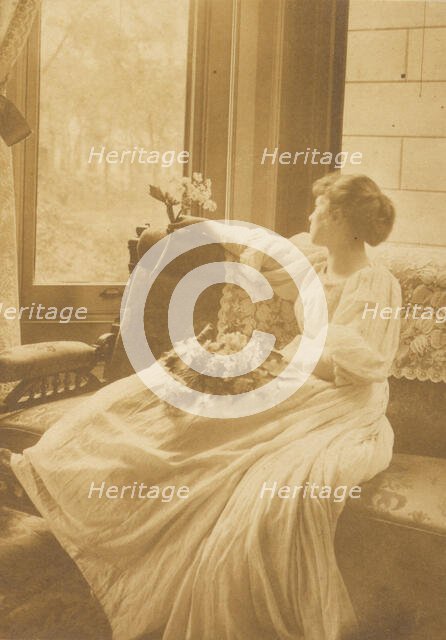Young woman seated by a window with flowers in her lap, c1900. Creator: Mary A. Bartlett.