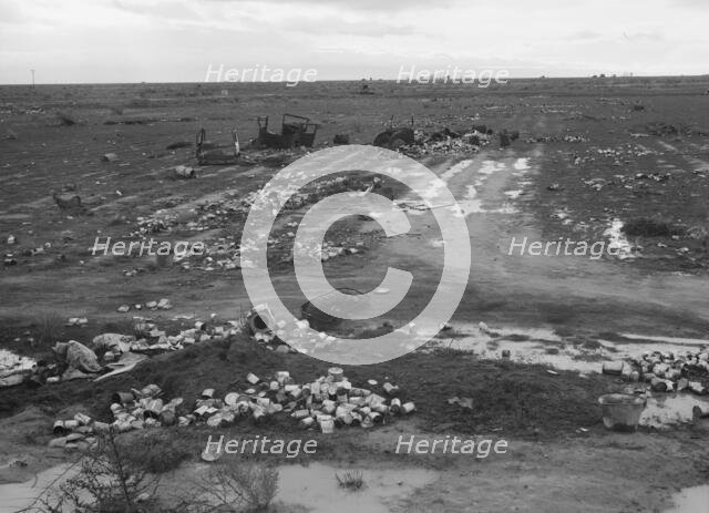 Debris left out on the flats where squatters' camp stood during work season, Kern County, 1939. Creator: Dorothea Lange.