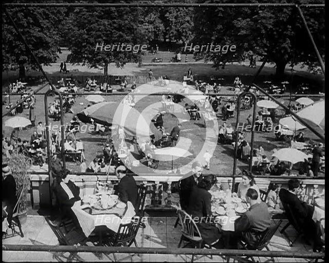 People Sitting at Tables on a Balcony While Another Group of People Sit Below, 1933. Creator: British Pathe Ltd.