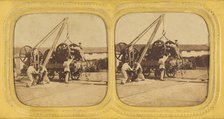 Men loading large iron wheels on platform, about 1865. Creator: Unknown.