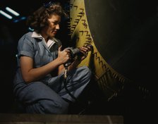 Riveter at work on Consolidated bomber, Consolidated Aircraft Corp., Fort Worth, Texas, 1942. Creator: Howard Hollem.