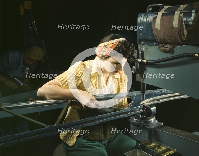 A girl riveting machine operator at the Douglas Aircraft Company plant..., Long Beach, Calif. , 1942 Creator: Alfred T Palmer.
