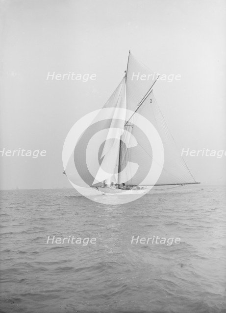 The 40-rater cutter 'Carina' sailing with spinnaker, 1913. Creator: Kirk & Sons of Cowes.