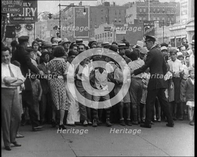 Crowded New York City Street Where Police and Ambulance Attend to Dead and Dying Victims..., 1932. Creator: British Pathe Ltd.