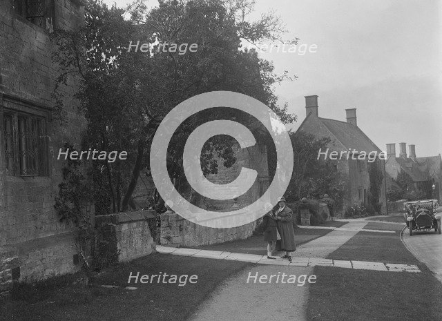 Unidentified 4-seater tourer in a village, c1920s. Artist: Bill Brunell.