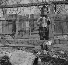 Boy playing in the backyard of his home, Washington (southwest section), D.C., 1942. Creator: Gordon Parks.