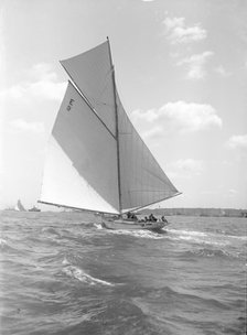 'Davo III', a 12 Metre class sailing yacht, runs before the wind, 1911. Creator: Kirk & Sons of Cowes.
