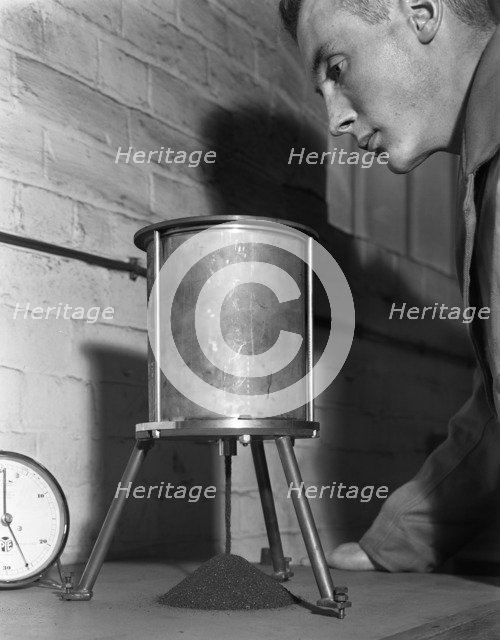 A lab technician undertaking a coal flow test, Mapperley Colliery, Derbyshire, 1962.  Artist: Michael Walters