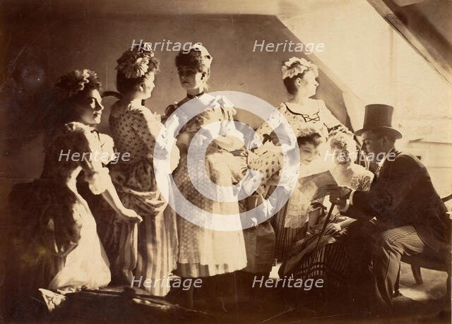 A Group of Six Costumed Women Posed in Interior with Top Hatted Gentlemen, c1885. Creator: Unknown.