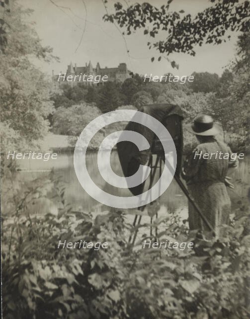 Photographer Frances Benjamin Johnston standing beside her large view camera looking..., c1938. Creator: Unknown.