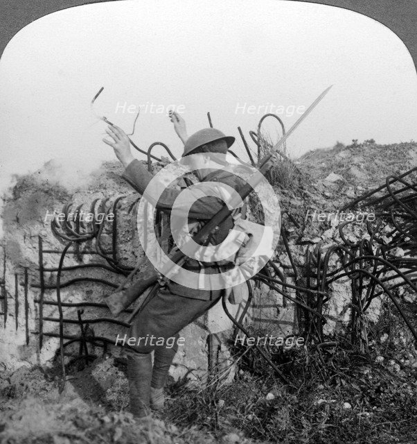 A soldier triggers a booby trap, World War I, 1914-1918.Artist: Realistic Travels Publishers