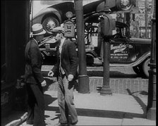 Male Civilian Stopping People On the Street Perhaps Begging or Perhaps Asking For a Job, 1932. Creator: British Pathe Ltd.