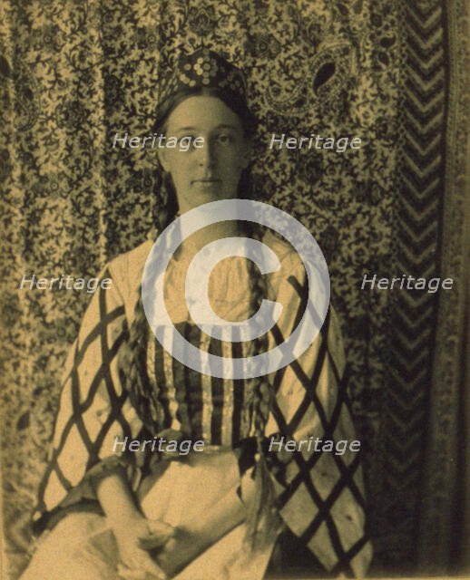 Portrait of a woman with braids in front of a paisley backdrop, c1900. Creator: Frances S. Allen.