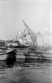 A crane unloading cargo from the 'Makalla' in Tilbury Docks, Essex, c1945-c1965. Artist: SW Rawlings