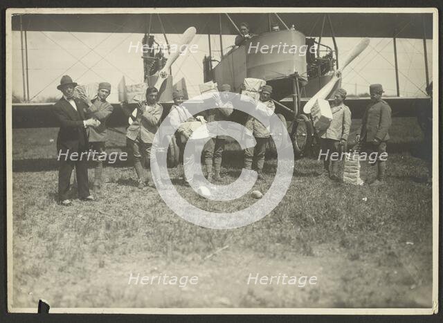 People loading supplies on airplane, 1919-1930. Creator: Fédèle Azari.