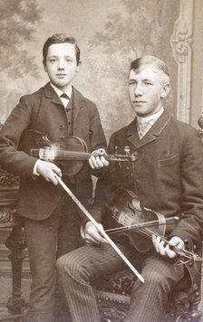 A father and son posing with their violins. Artist: Unknown