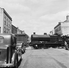 Goods vehicles being shunted across the un-gated level crossing in High Street, Tewkesbury, 1947. Creator: Marjory L Wight.