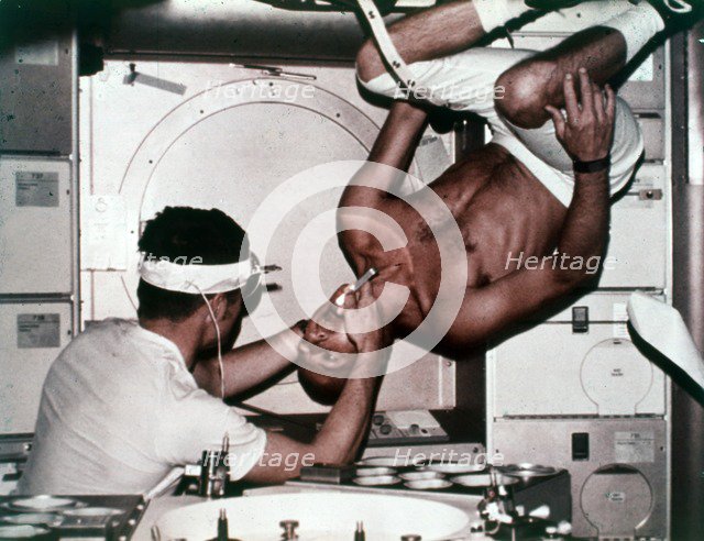 Kerwin examining Conrad on Skylab 2, 1973. Creator: NASA.