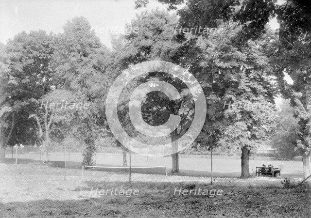 Grass tennis court among trees, c1935. Creator: Kirk & Sons of Cowes.