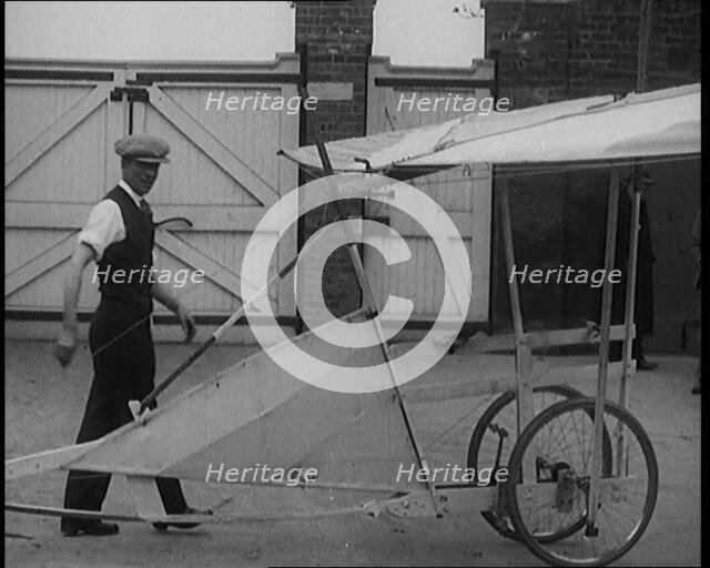 Male Civilian Carrying a Small Pedal Powered Flying Machine and Trying to Demonstrate It in..., 1929 Creator: British Pathe Ltd.