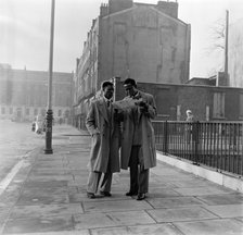 Two Afro-Caribbean men reading a map in the street, London, (c1950s?).   Creator: Henry Grant.