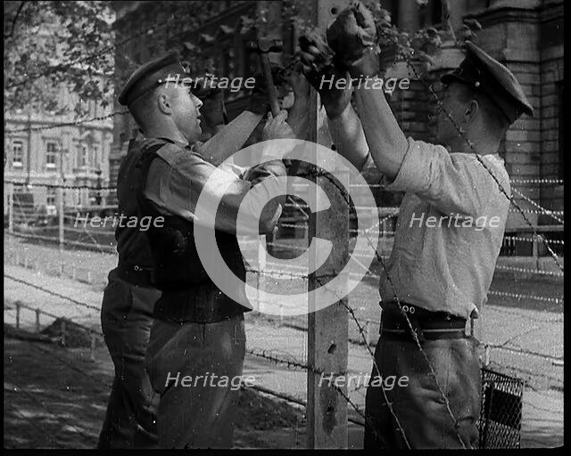 Three Men Setting up a Barbed Wire Fence, 1940. Creator: British Pathe Ltd.