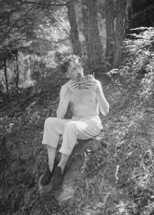 Man playing panpipes in the woods, between 1911 and 1942. Creator: Arnold Genthe.