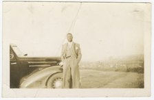 Photograph of an unidentified man in front of car, ca. 1920. Creator: Unknown.