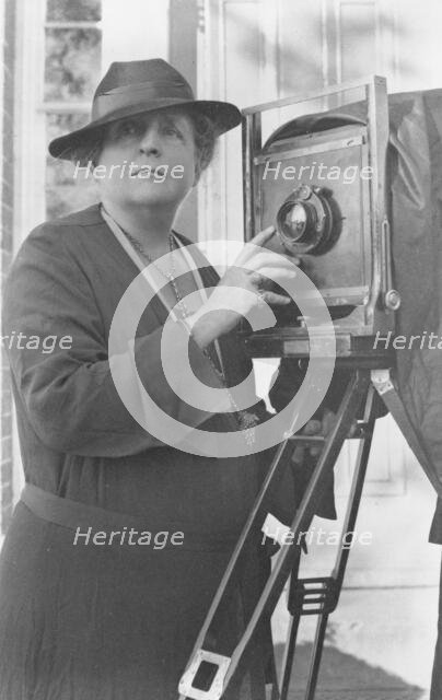 Frances Benjamin Johnston, 1864-1952, half length, facing front, adjusting lens..., c1936. Creator: Frances Benjamin Johnston.
