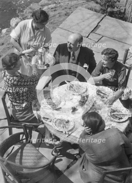 Mrs. Mary Benson and other people seated outdoors, 1933. Creator: Arnold Genthe.