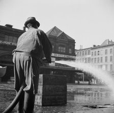 Workmen from the sanitary department flushing the street in front of the Fulton..., New York, 1943. Creator: Gordon Parks.