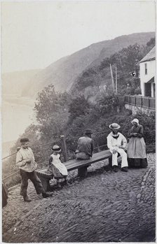 People gathered by the bench at the Lookout in Clovelly, 1860s. Creator: Unknown.