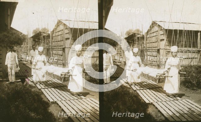 Japanese nurses carrying a patient on a stretcher, c1905. Creator: Underwood & Underwood.