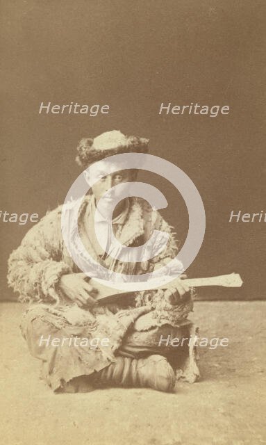 Kazakh man, a musician with a dombra, seated, between 1870 and 1886. Creator: Unknown.