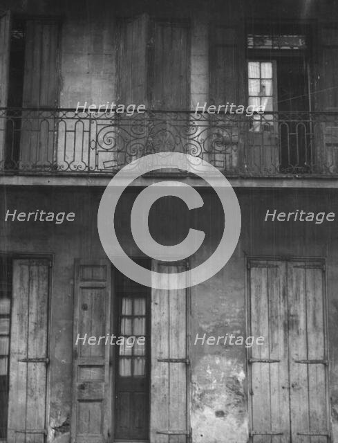 Facade of a building with shuttered doors and balcony, New Orleans or Charleston..., c1920-1926. Creator: Arnold Genthe.