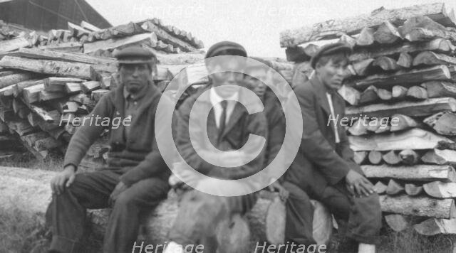 Men sitting on logs, between c1900 and 1916. Creator: Unknown.