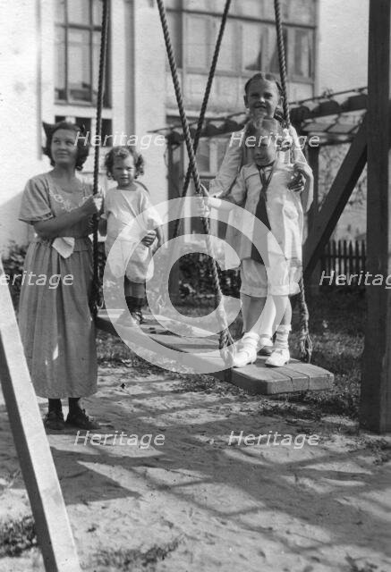 Irina, Yuliy and Vera Briner with nanny Katya in the courtyard of a house on Svetlanskaya St, 1923. Creator: Unknown.