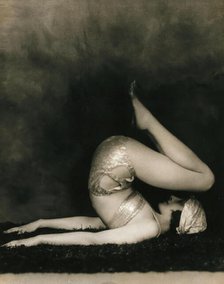 Marguerite Agniel posing with her back arched and feet in the air, wearing a two-piece cos..., 1929. Creator: Unknown.