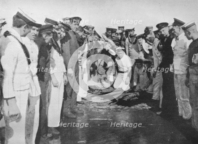 'British sailors round a hole in the deck of their vessel', 1915. Artist: Unknown.