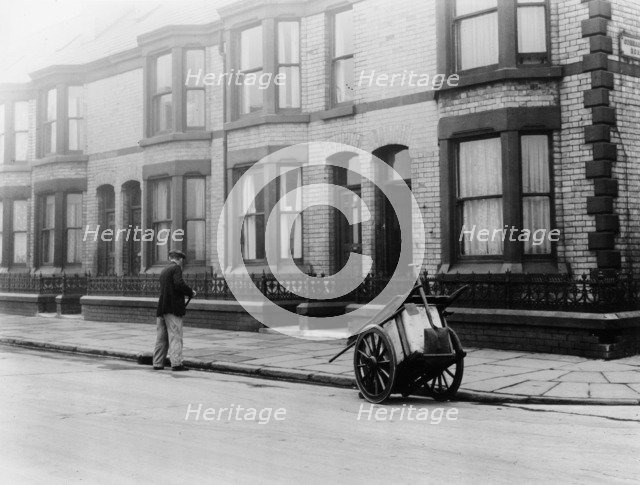 An 'Orderly Boy' and his cart sweeping a street, Liverpool, 1935. Artist: Unknown