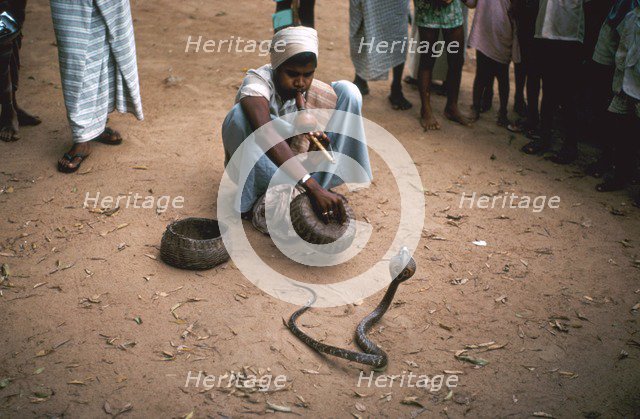 Snake charmer with cobra, in Sri Lanka. Artist: Unknown