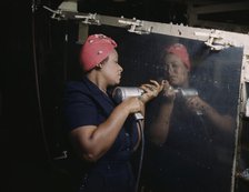 Operating a hand drill at Vultee-Nashville...working on a "Vengeance" dive bomber, Tennessee, 1943. Creator: Alfred T Palmer.