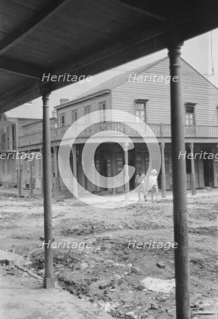 Two men crossing an unpaved street, New Orleans or Charleston, South Carolina, between 1920 and 1926 Creator: Arnold Genthe.