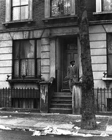 A man standing outside a house in Westbourne Grove, possibly in Kensington, London, 1950s. Creator: Henry Grant.