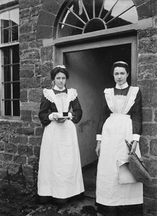 Two housemaids standing in the doorway of a house, Byfield, Northamptonshire, c1896-c1920. Artist: A Newton